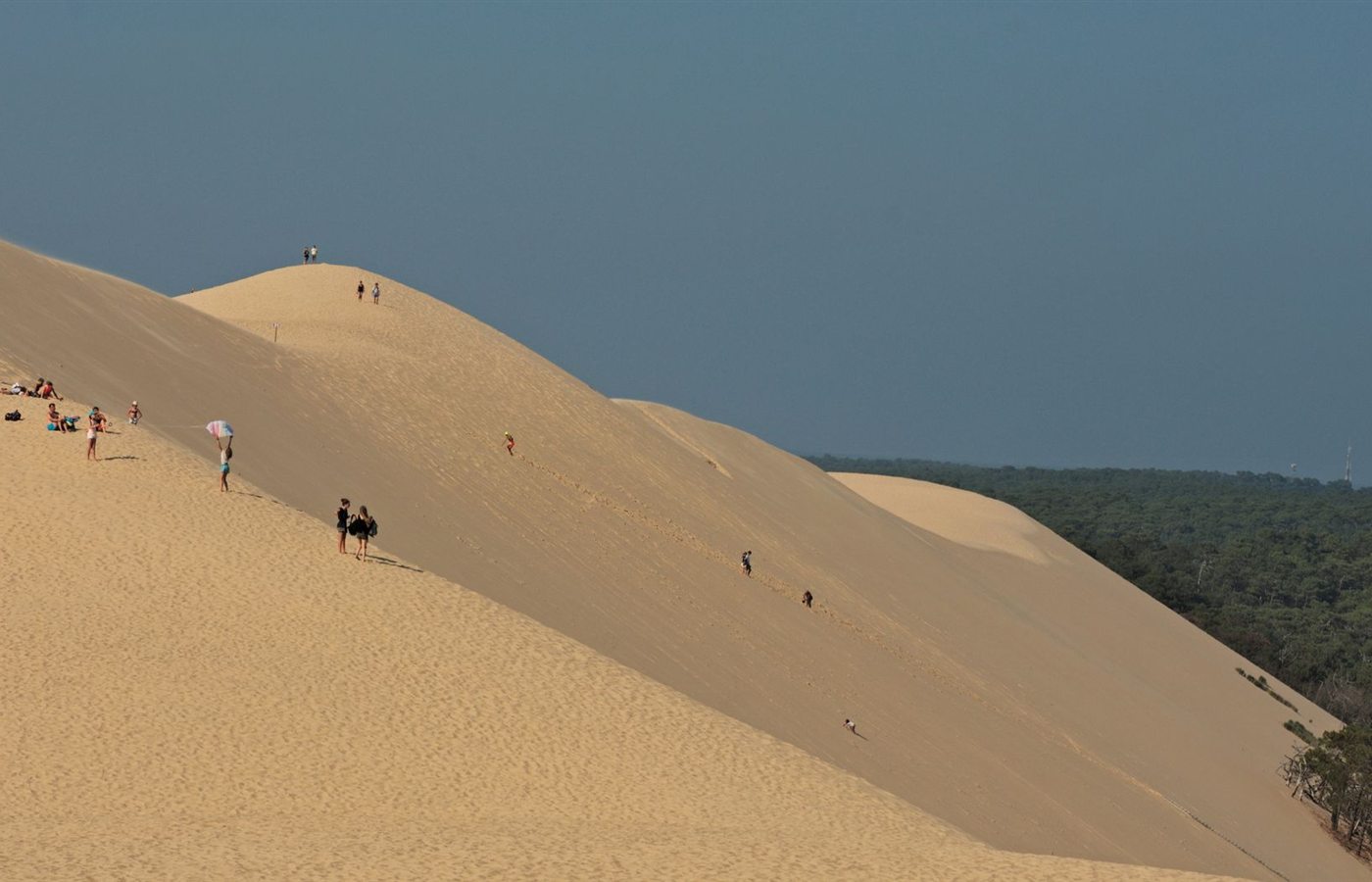 Visitors enjoying the vast sands of the Dune of Pilat, France's famous natural landmark.