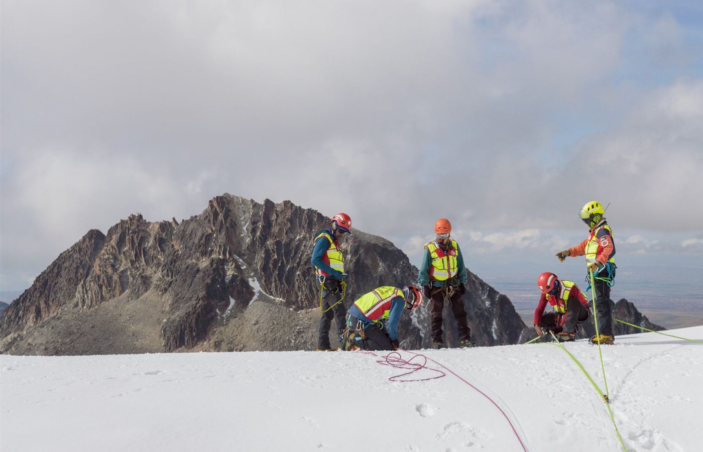 A group of climbers in safety gear conducting a winter mountain expedition.